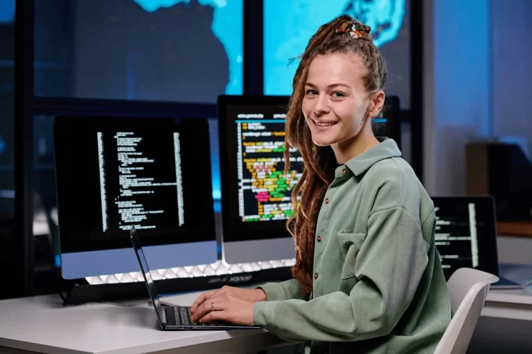 database developer at a workstation surrounded by screens